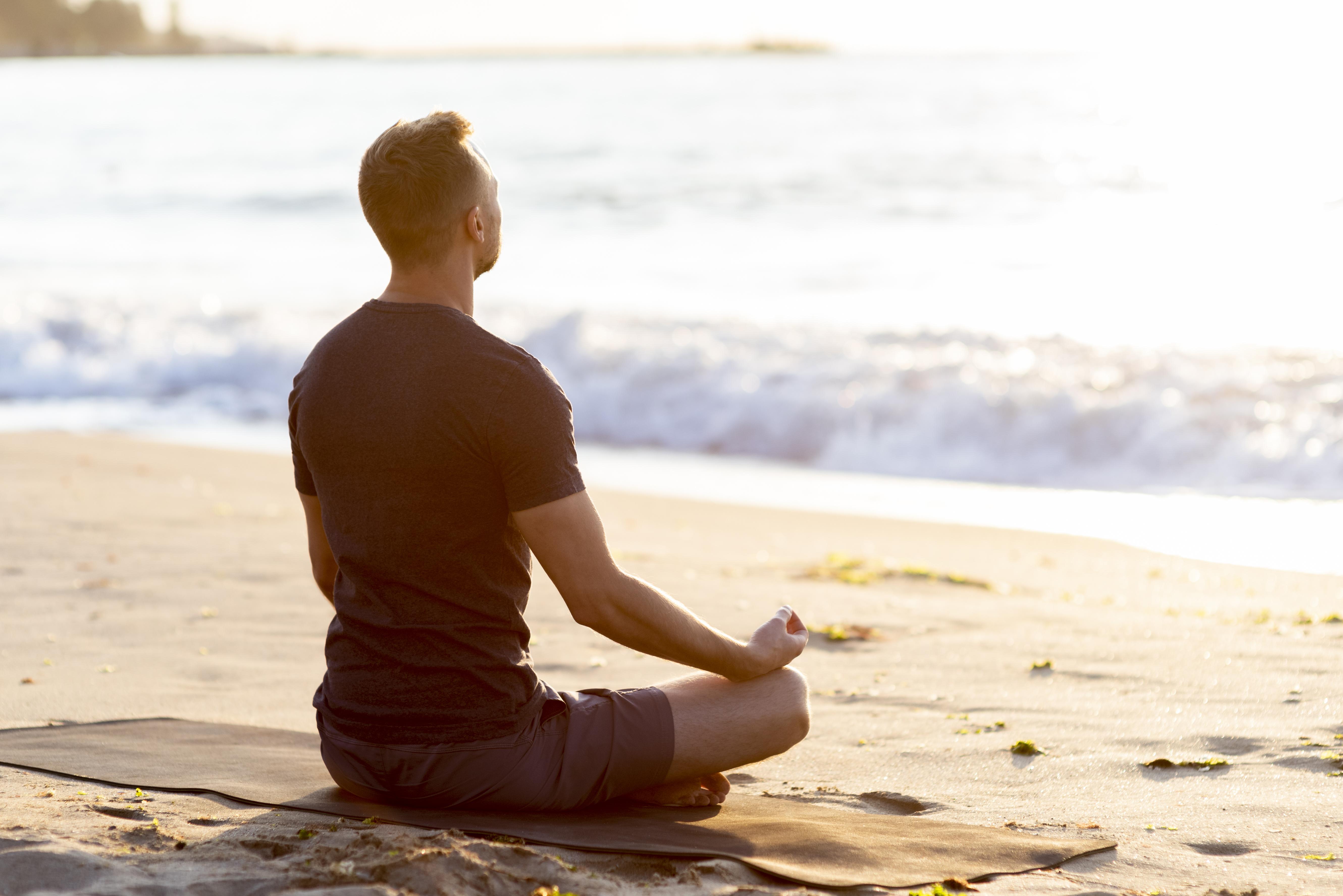 Man meditating on the beach